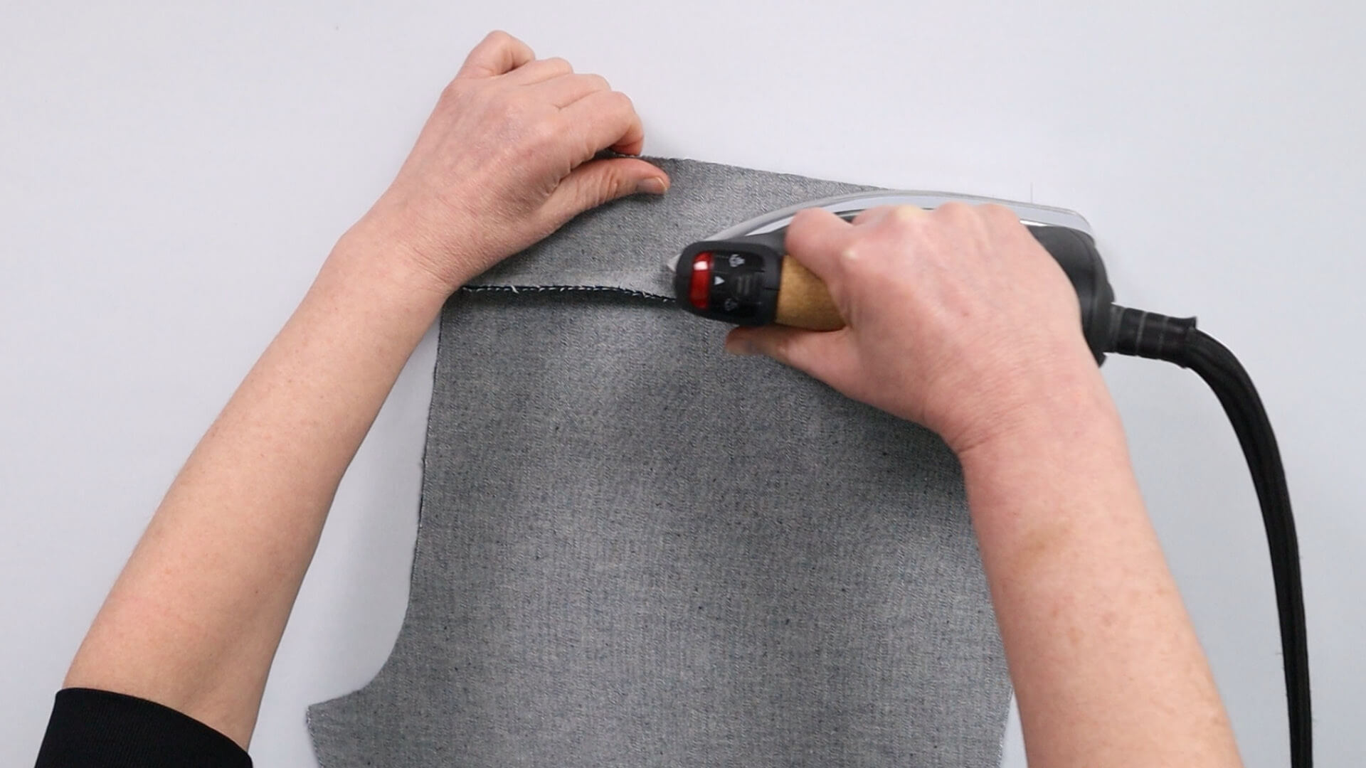 The picture shows how the saddle seam of the jeans is ironed over.