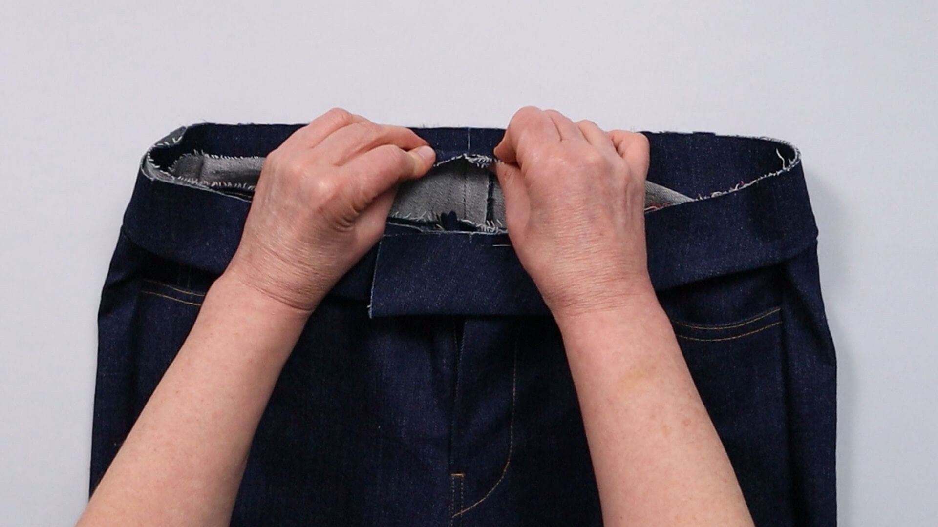 smartPATTERN Nähanleitung zum Vorbereiten einer Jeanshose-zur Anprobe - Bund mit Knips an hinterer Mitte feststecken