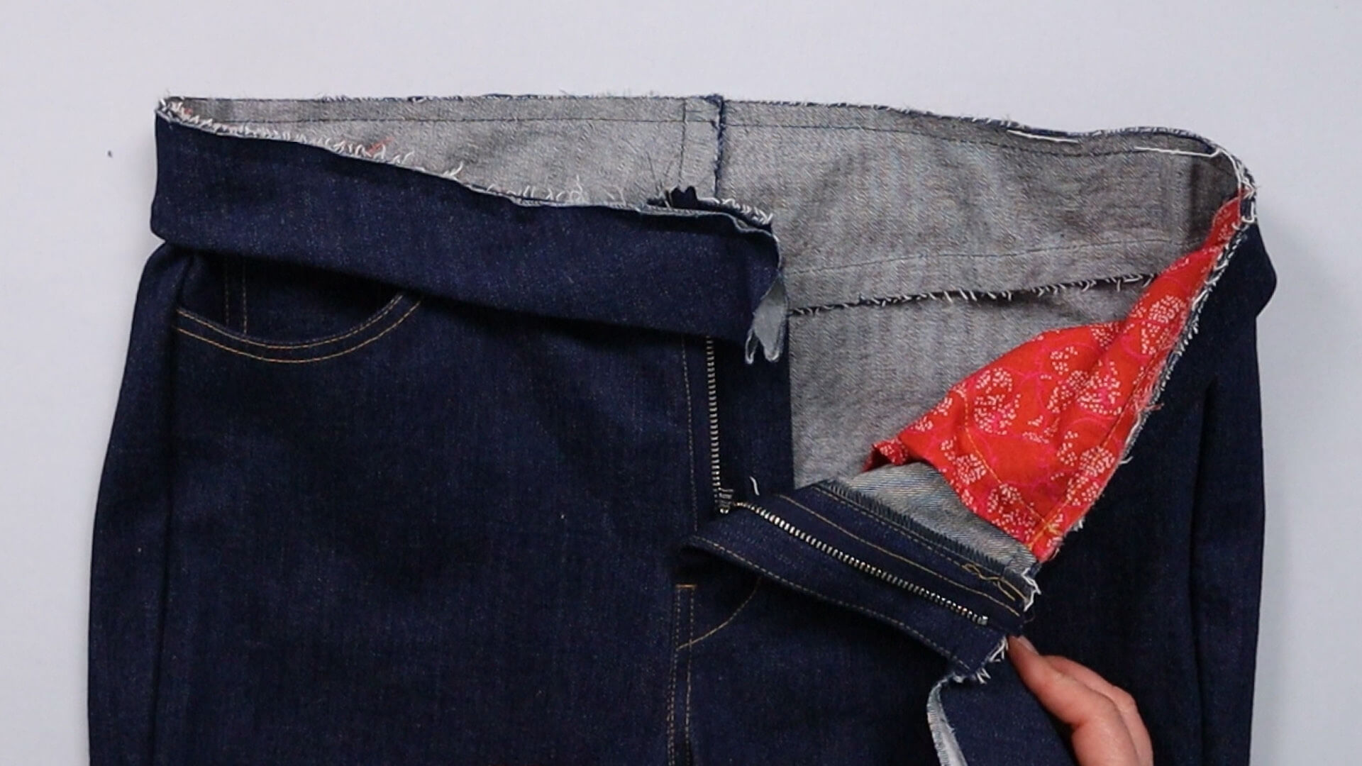the waistband is sewn onto the jeans to try them on
