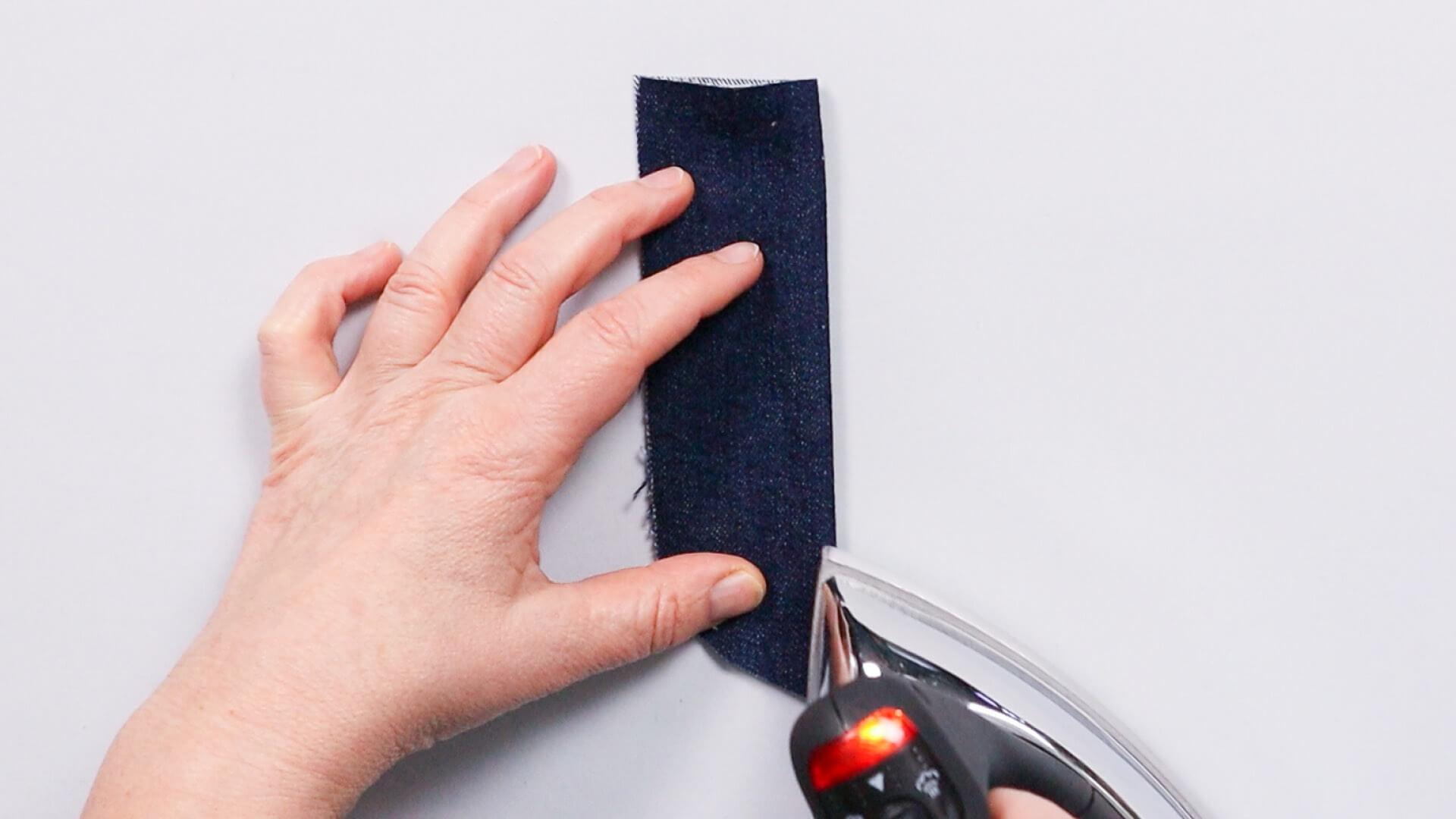 smartPATTERN Nähanleitung für Schlitz mit verdeckter Knopfleiste einer Jeans- Schlitzleiste mittig zusammenbügeln