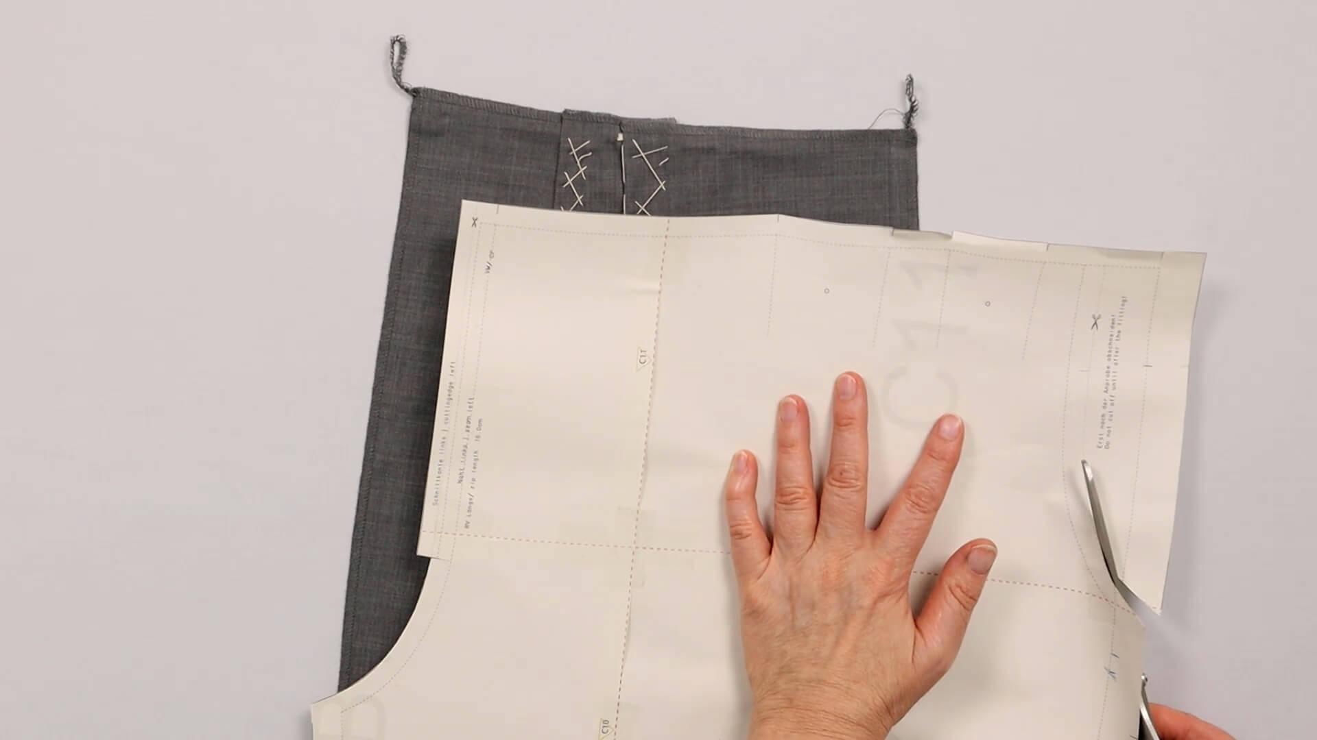 Das Bild zeigt, wie der Tascheneingriff am Schnittmuster weggeschnitten wird.