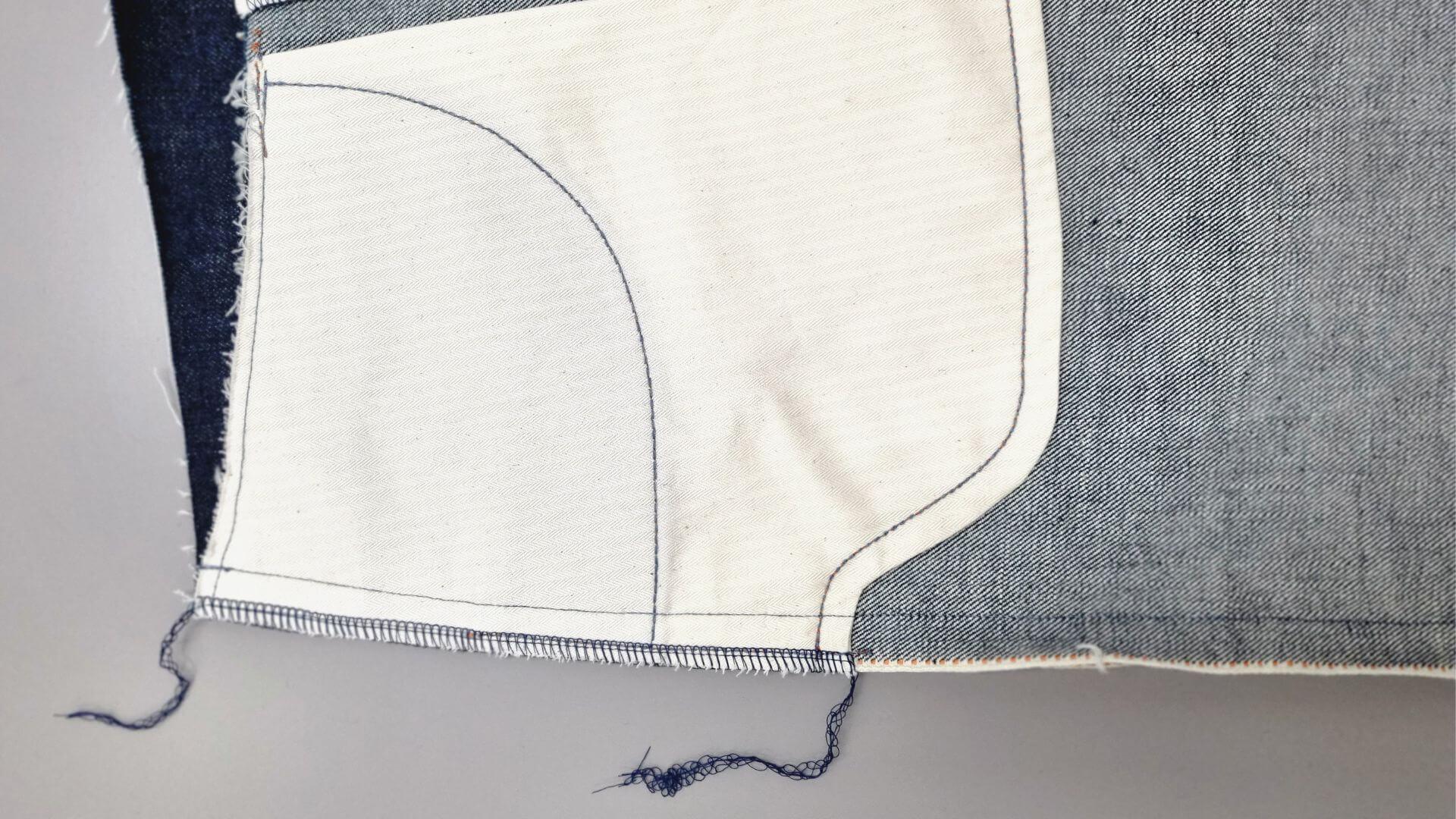 at pocket area overlocked side seam on selvedge trousers