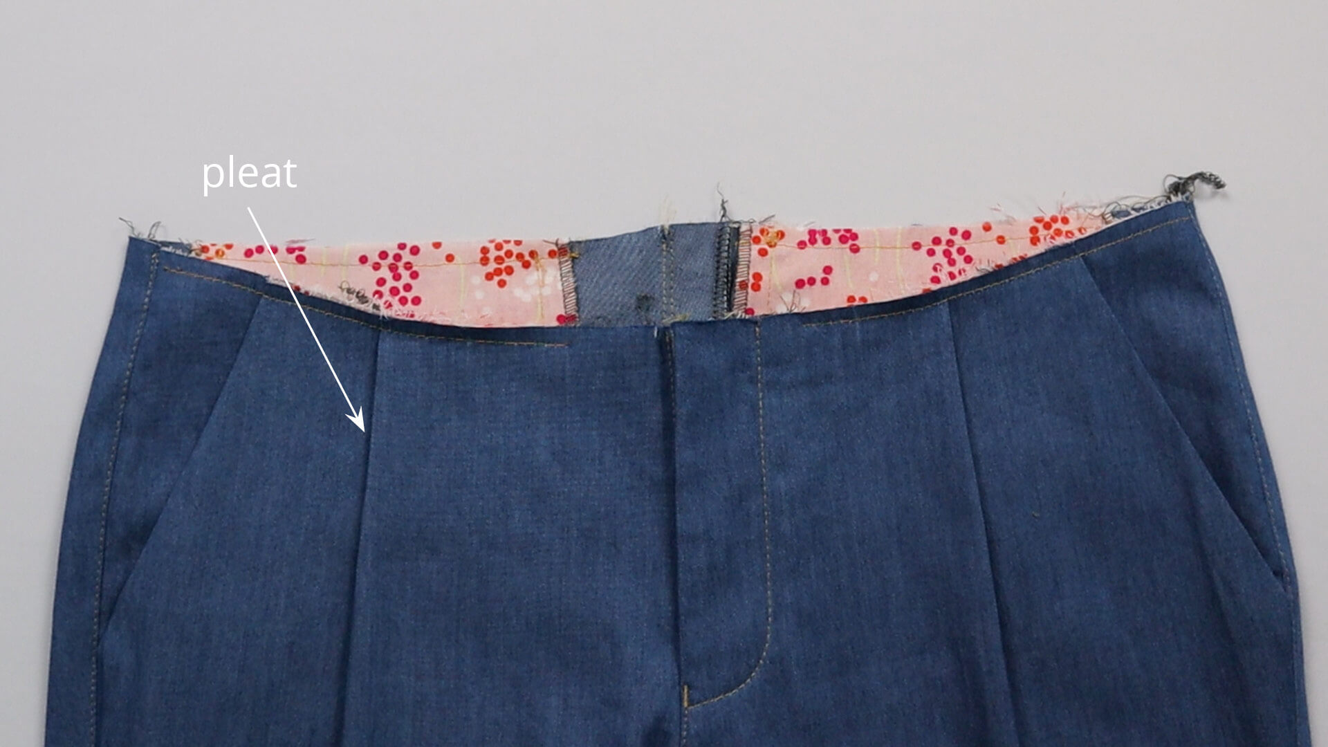 The picture shows how a pleat is folded and fastened before the waistband is sewn on.