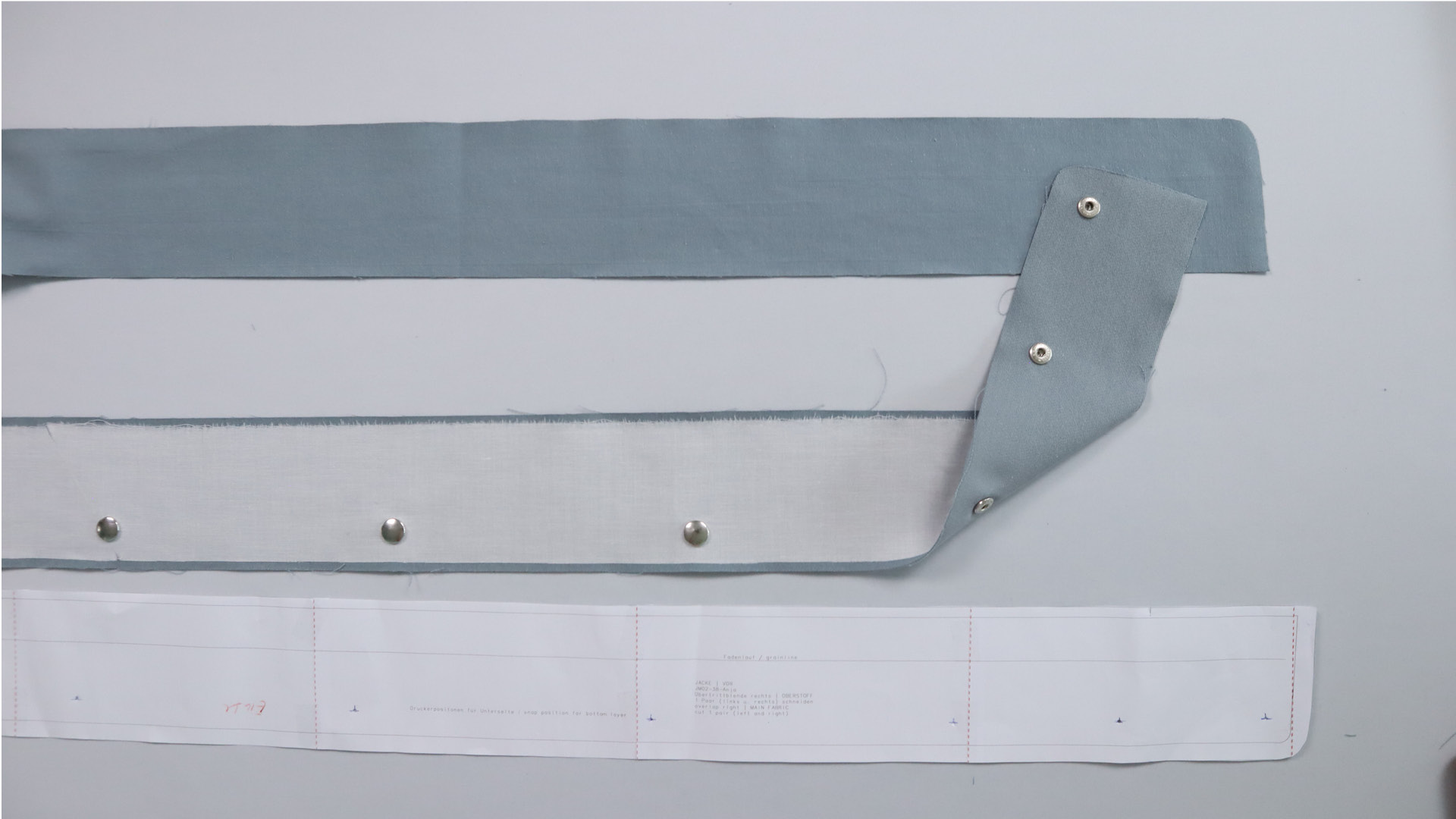 Parka mit Kapuze nähen - Die Oberteile der Druckknöpfe kommen an den Übertritt.