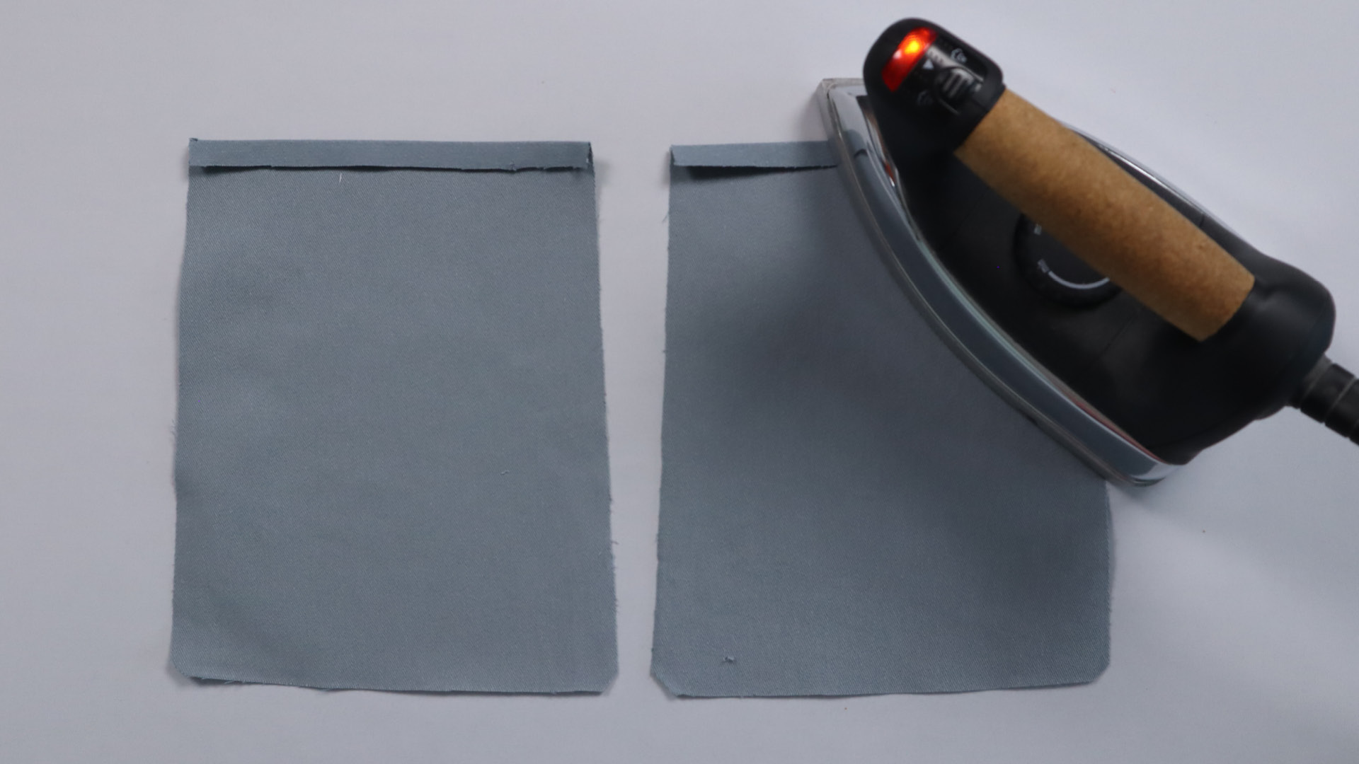 Parka mit Kapuze nähen - Die obere Kante des unteren Taschenbeutels wird 1 cm breit nach außen gebügelt.