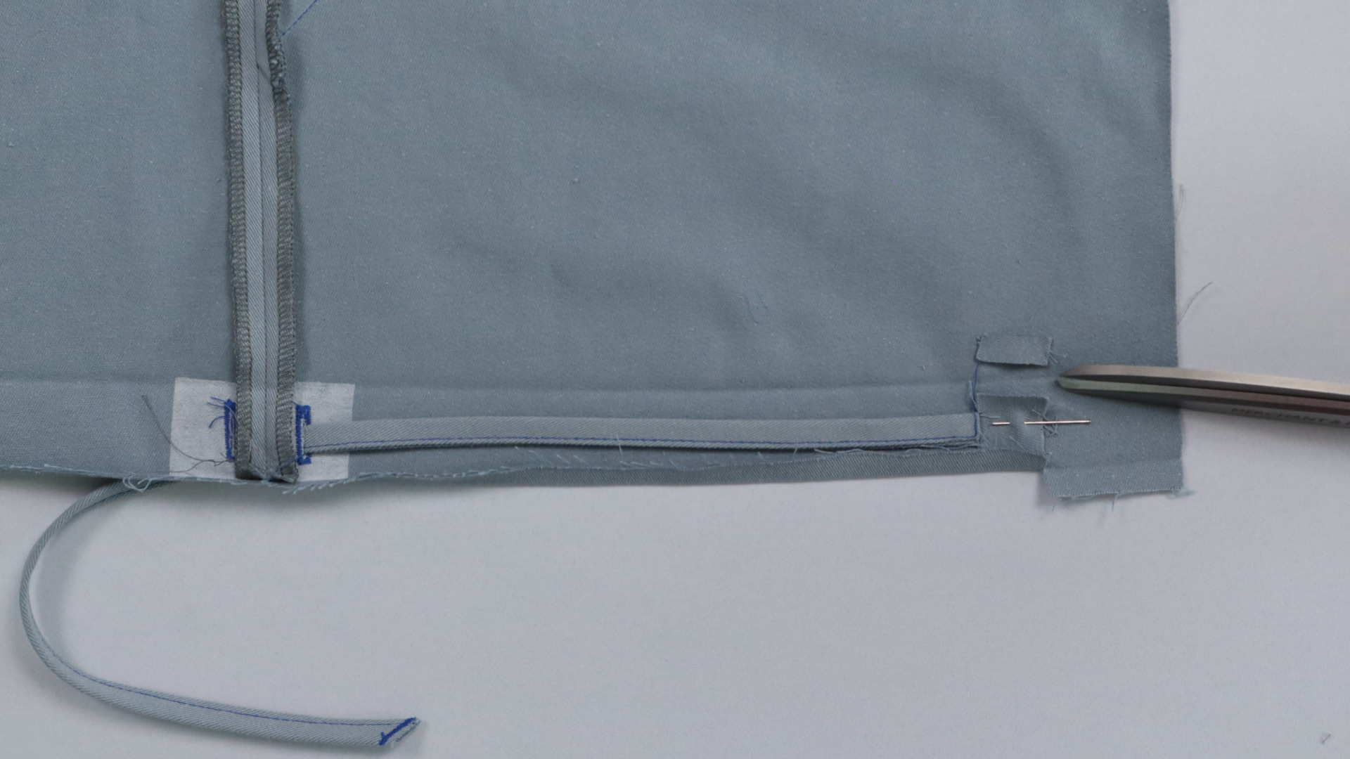 Parka mit Kapuze nähen - Das Band wird festgesteckt.