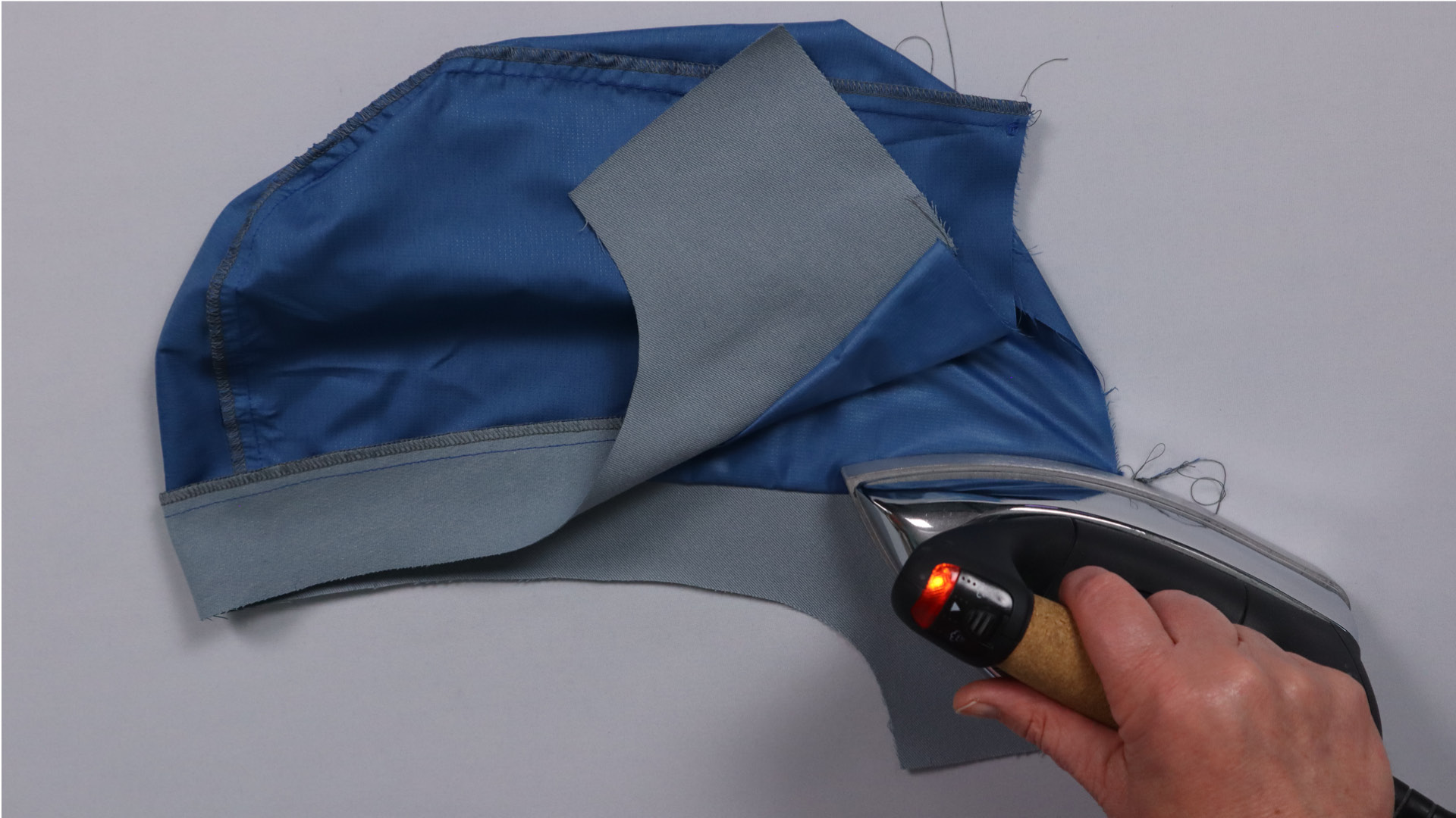 Parka mit Kapuze nähen - Die Nahtzugabe wird nach hinten gebügelt.