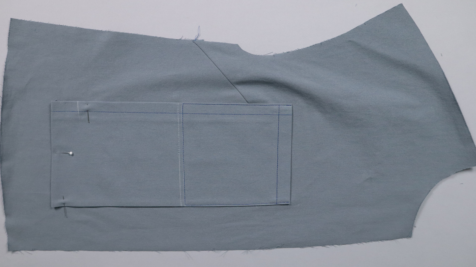 Jacke mit Kapuze nähen - Die obere Tasche wird festgesteppt.