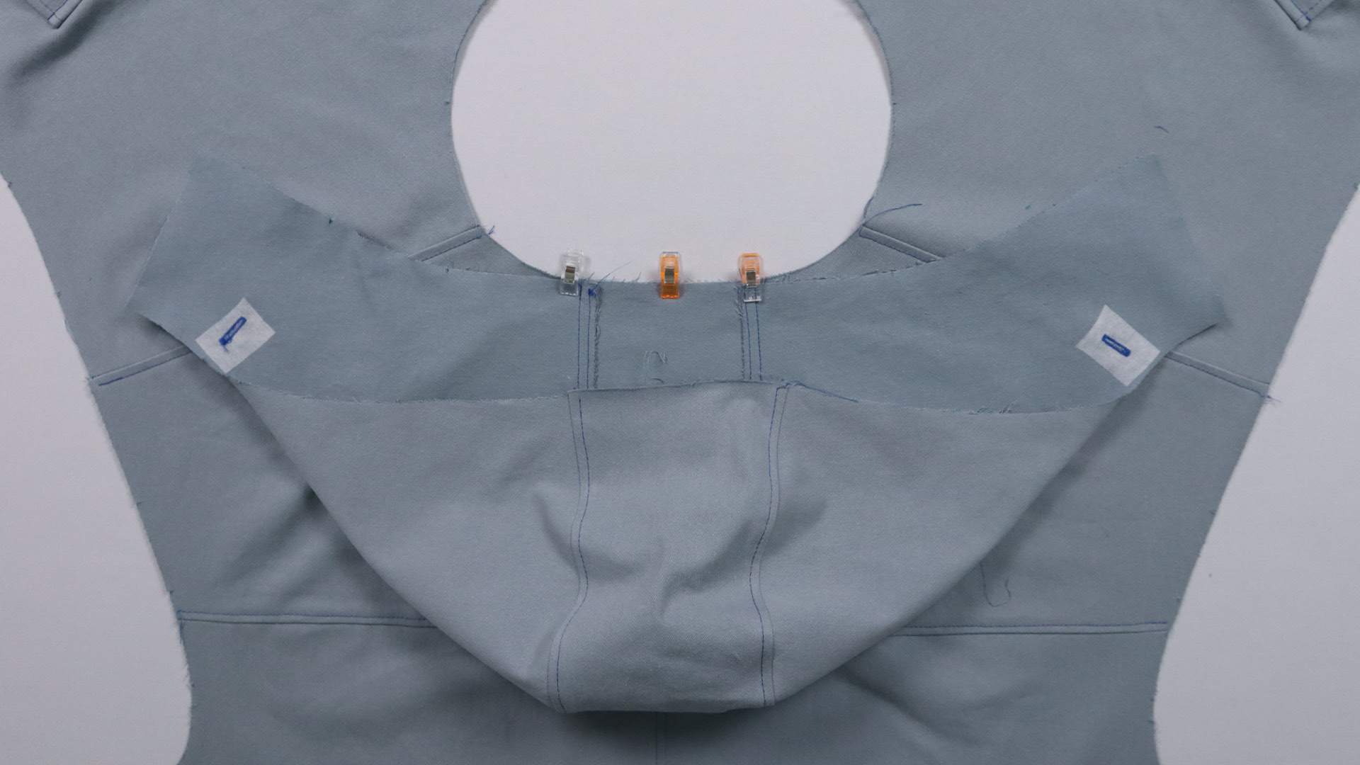 Die Kapuze wird an der hinteren Mitte an das Halsloch gesteckt.