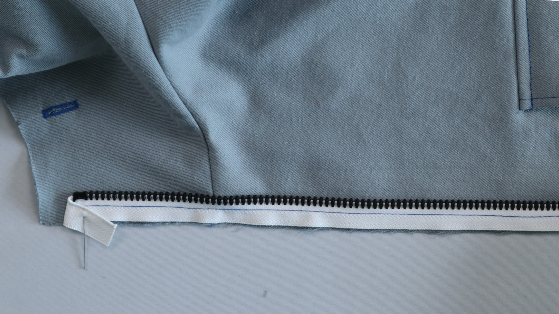 Jacke mit Kapuze nähen - Die Reißverschlussenden werden umgeschlagen.