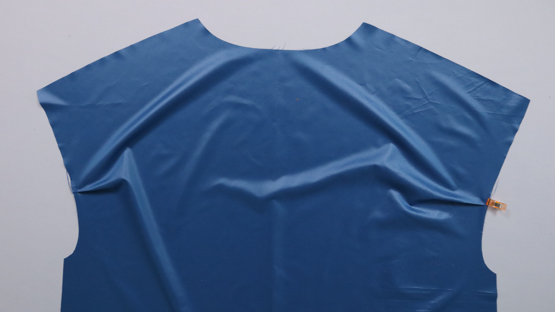 Jacke mit Kapuze nähen - Falte am Rückenteil legen und heften.