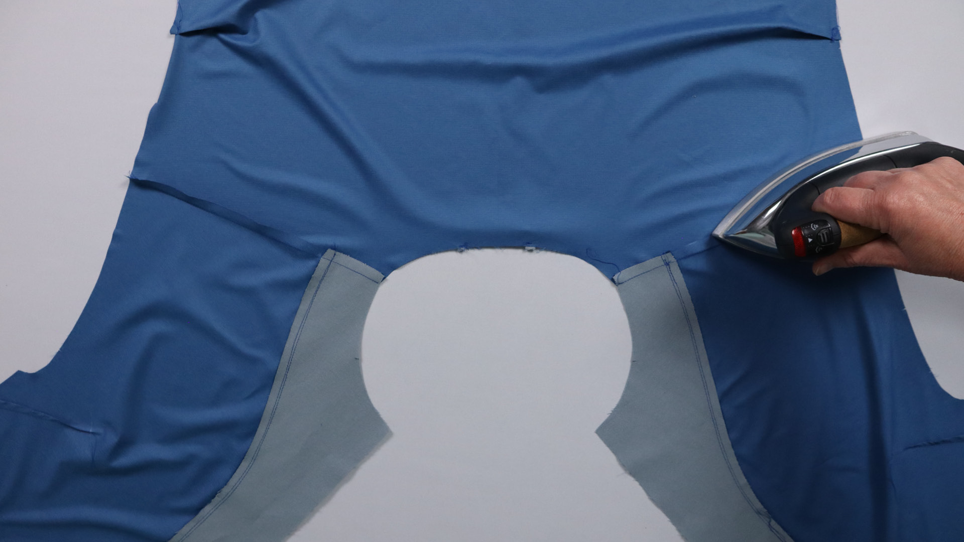 Jacke mit Kapuze nähen - Nahtzugaben zum Rückenteil bügeln.