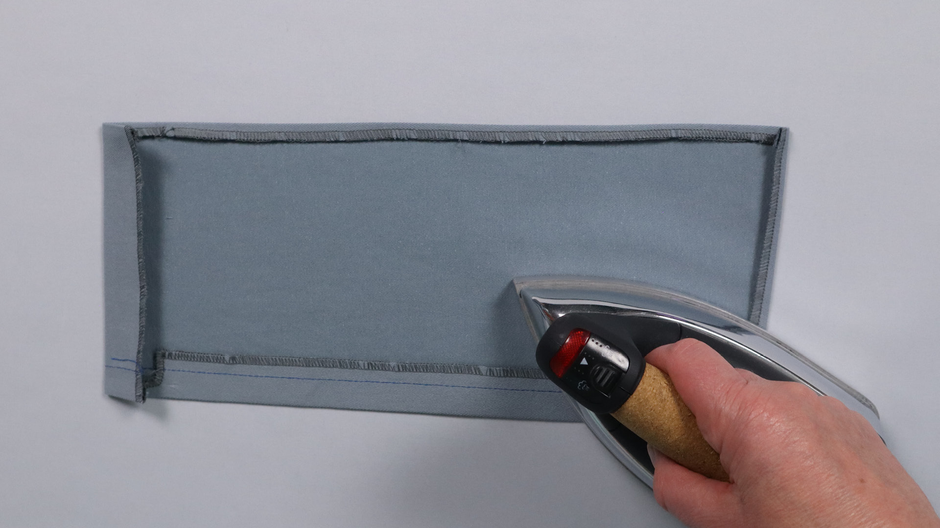 Jacke mit Kapuze nähen - Kanten der Tasche bügeln.