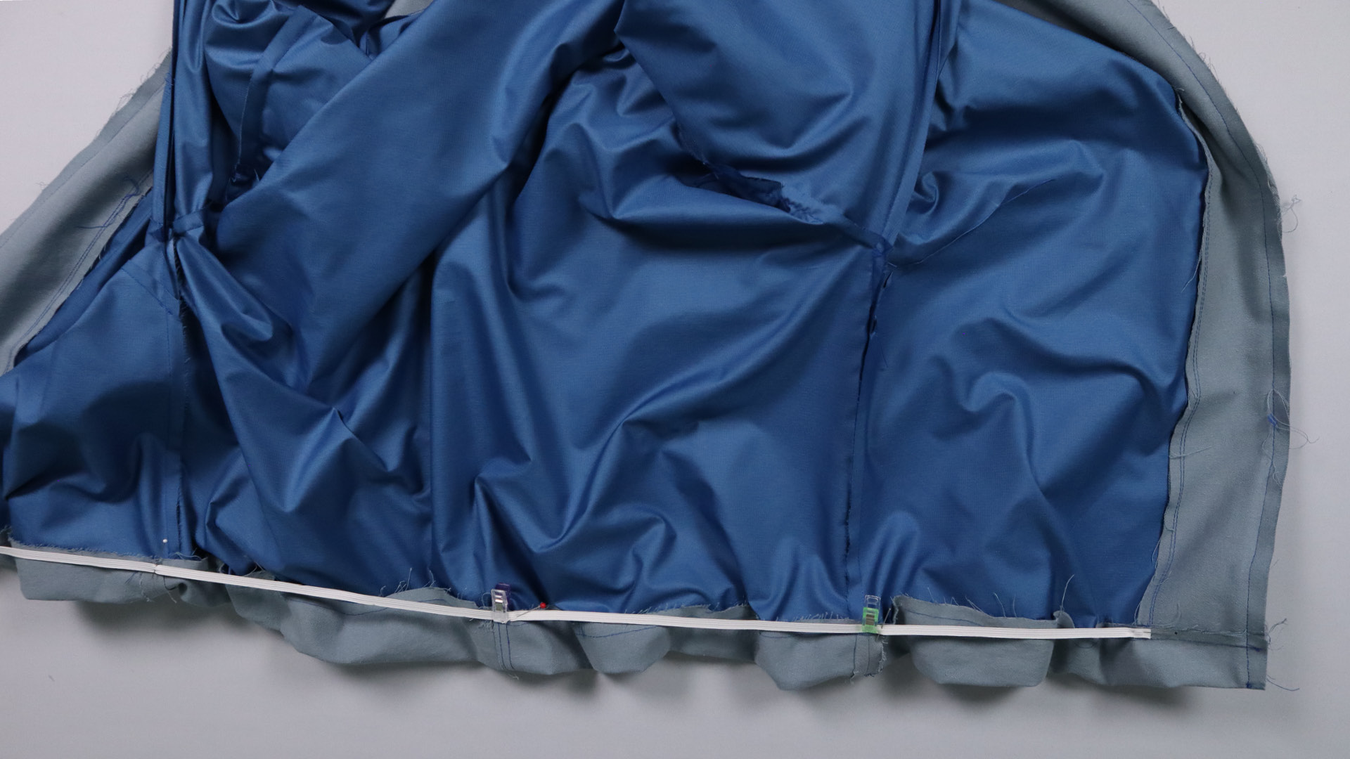 Jacke mit Kapuze nähen - Das Gummiband wird gesteckt.