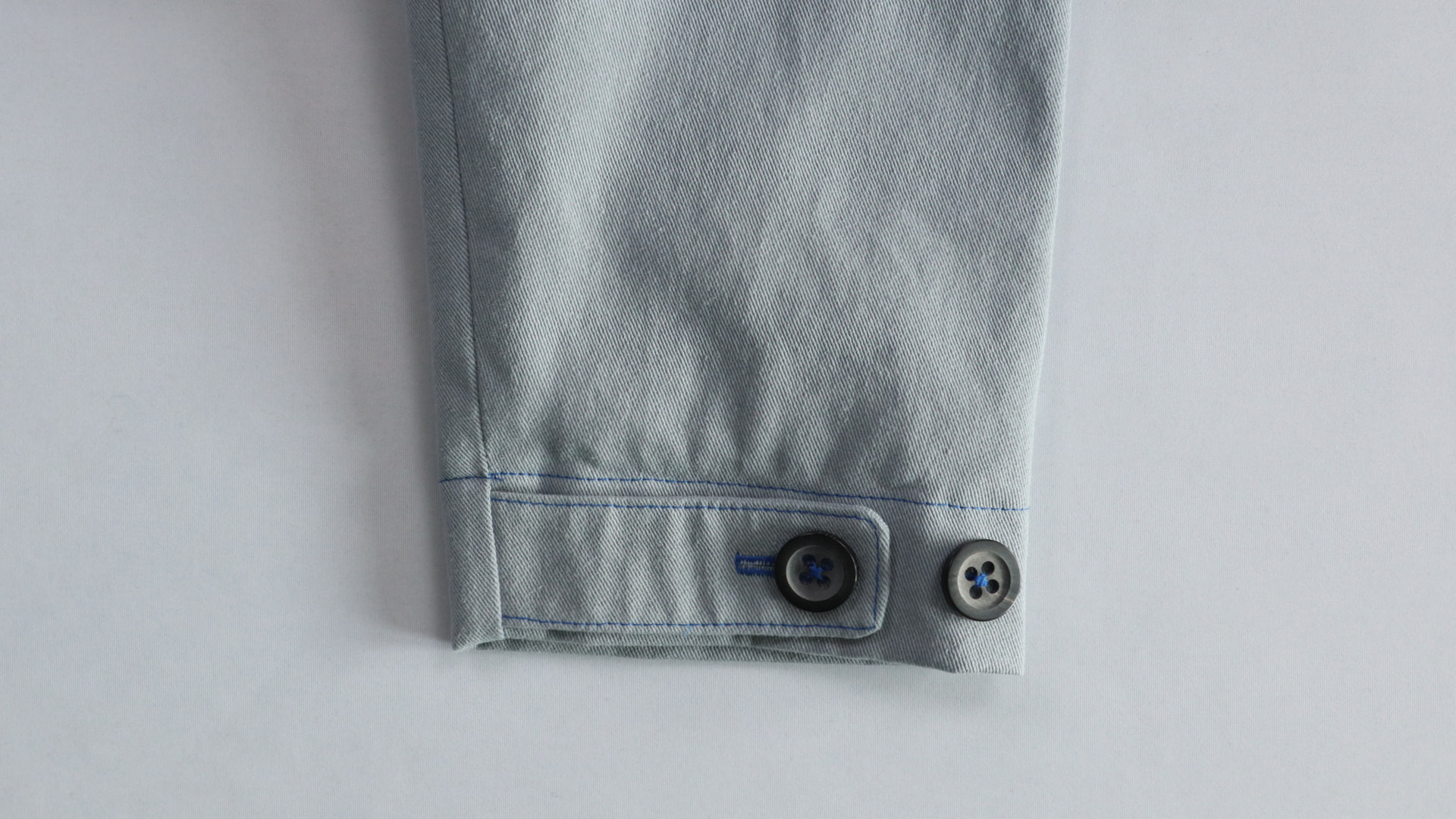 Jacke mit Kapuze nähen - Die Knöpfe werden angenäht.