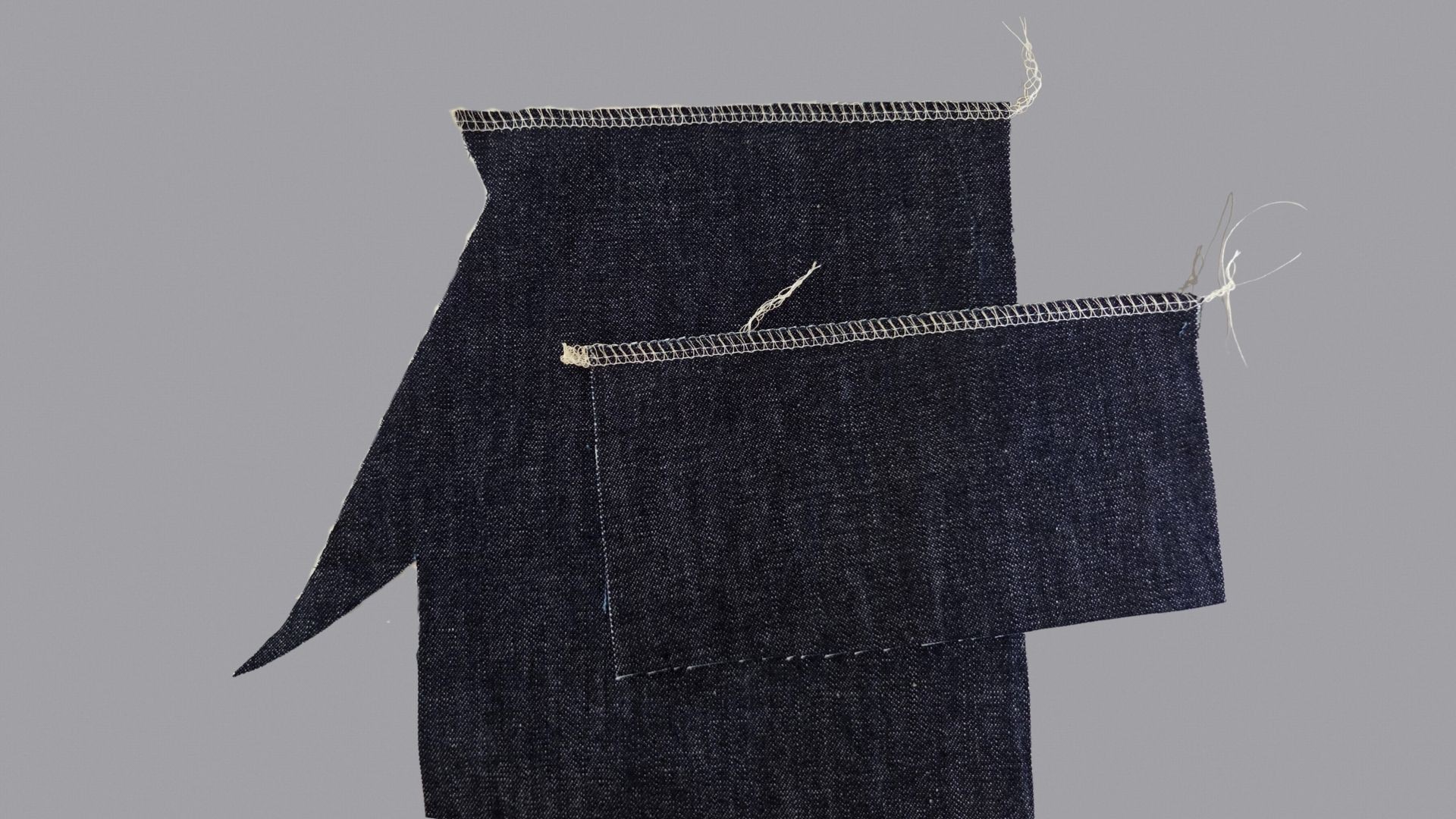 Das Bild zeigt, wie die aufgesetzten Taschen versäubert werden.