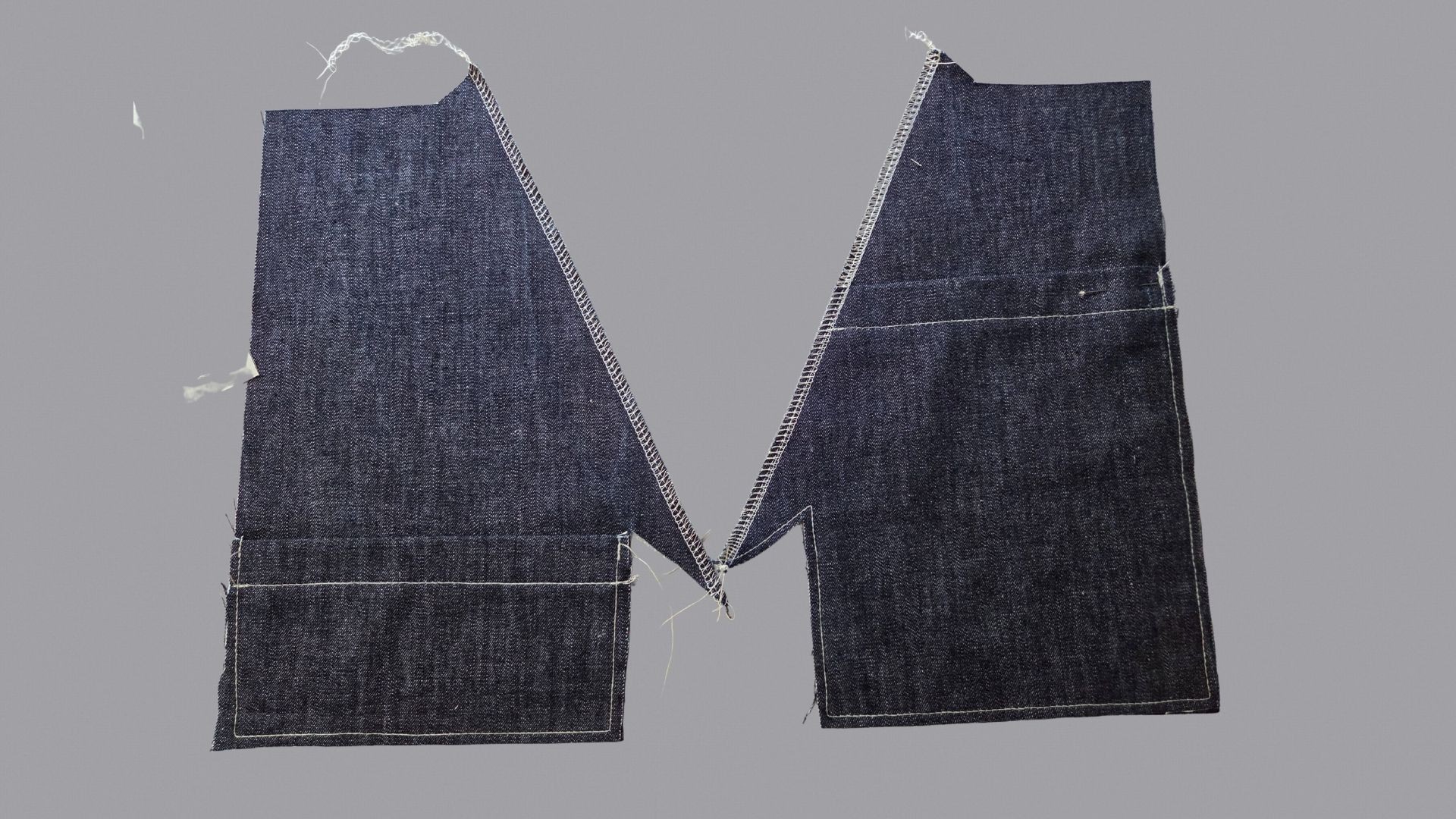 Das Bild zeigt die aufgesetzten Taschen und versäuberte Tascheneingriffe.